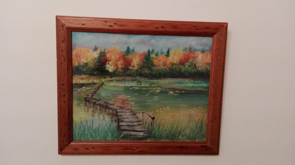 Una pintura de un puente de madera sobre un cuerpo de agua, con árboles al fondo.