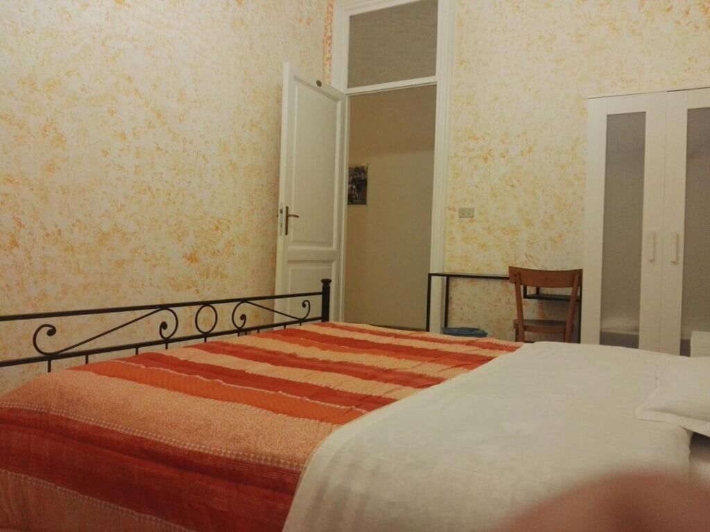Un dormitorio con cama, armario y puerta que da a otra habitación.