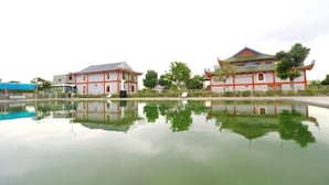 A traditional building with a reflection in a calm water body. - Resort Huu Bang (Hai Phong)