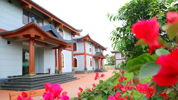A traditional building with multiple levels and a tiled roof. - Resort Huu Bang (Hai Phong)