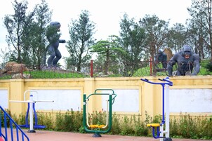 A playground with exercise equipment and two gorilla statues.
