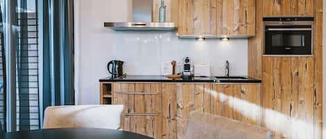A modern kitchen with wooden cabinetry, a black countertop, and a built-in oven.