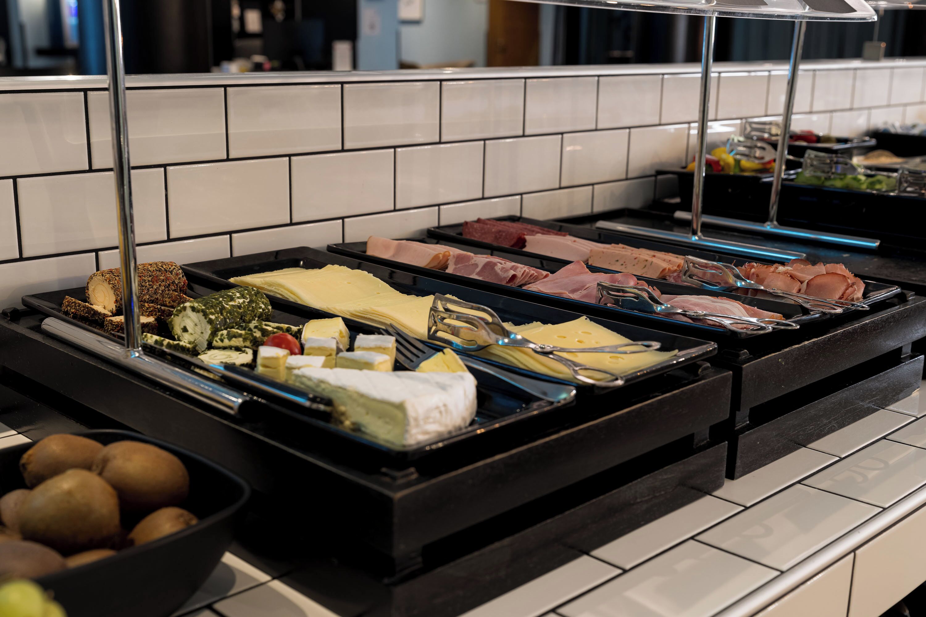 Ein Buffet mit verschiedenen Speisen, darunter Fleisch-, Käse- und Gemüsesorten.