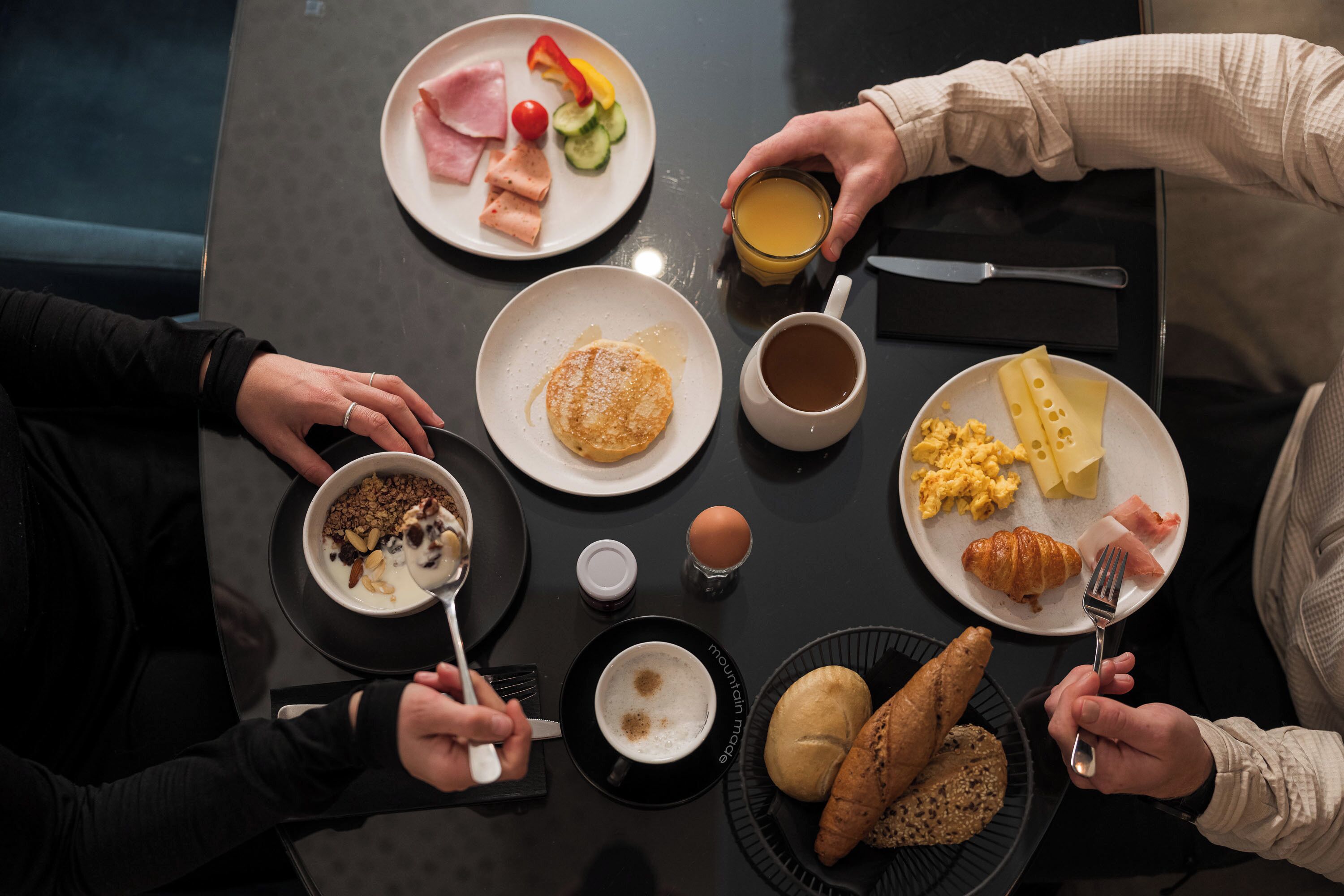 A breakfast setting with various food items and drinks on a table.