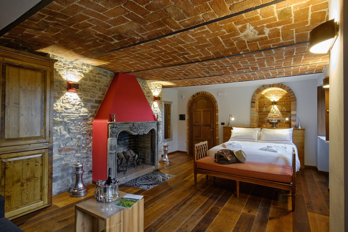 Een knus ingerichte kamer met een open haard, houten meubels en een bed.