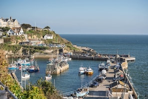 A coastal marina with boats docked, a pier, and residential buildings on a hillside. - Spacious Flat, Sea Views & Private Parking, Fistral (Newquay)