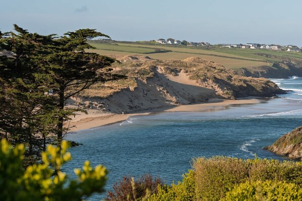 A coastal landscape with a sandy beach, a rocky cliff, and a clear view of the ocean. - Spacious Flat, Sea Views & Private Parking, Fistral (Newquay)