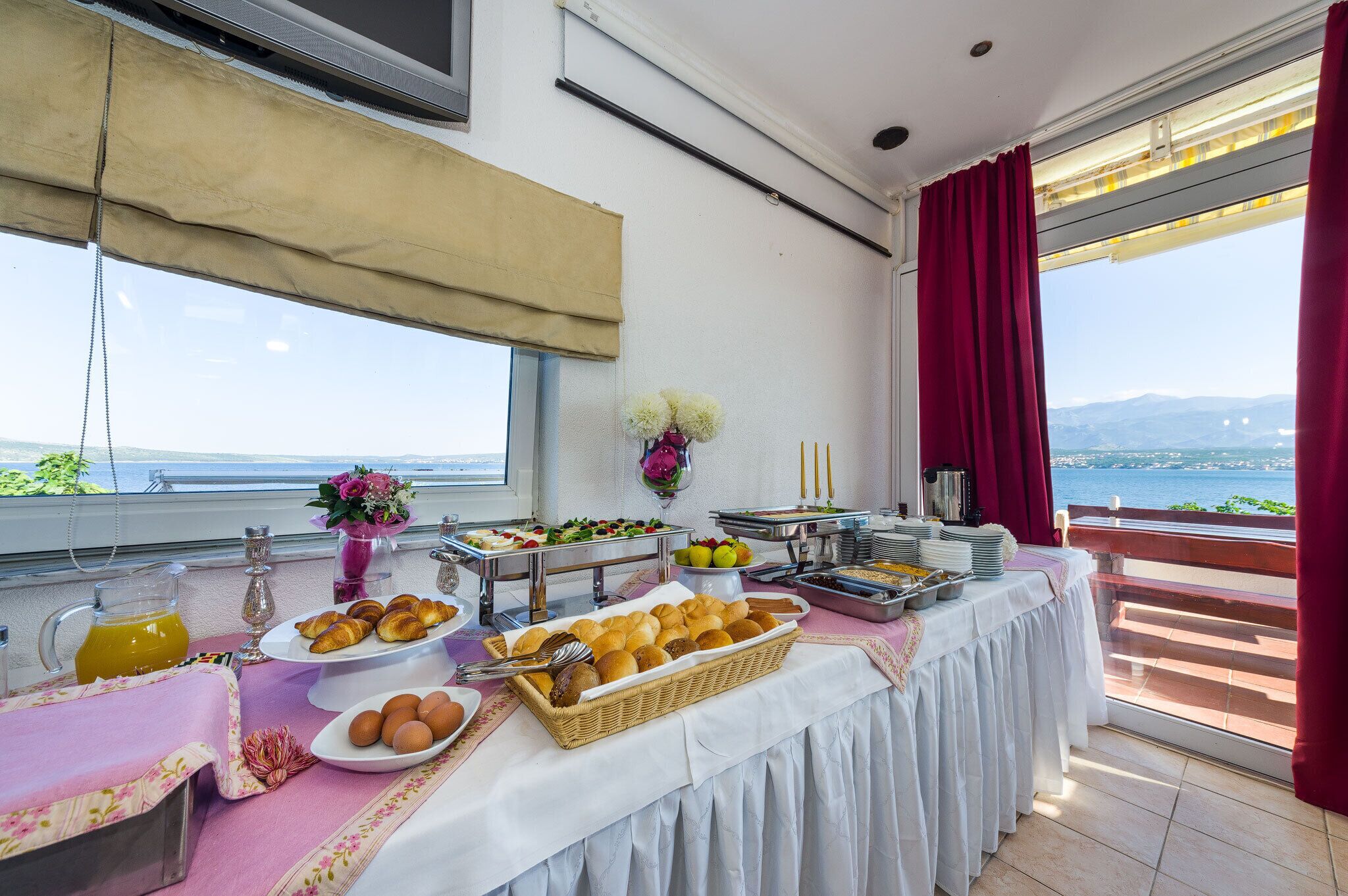 A buffet setup with various food items and a scenic view.