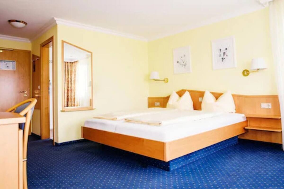 Een hotelkamer met een bed, een bureau en een stoel.