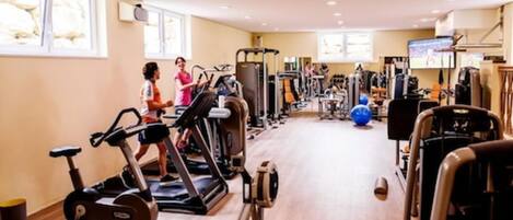A gym with treadmills, stationary bikes, and weight machines.