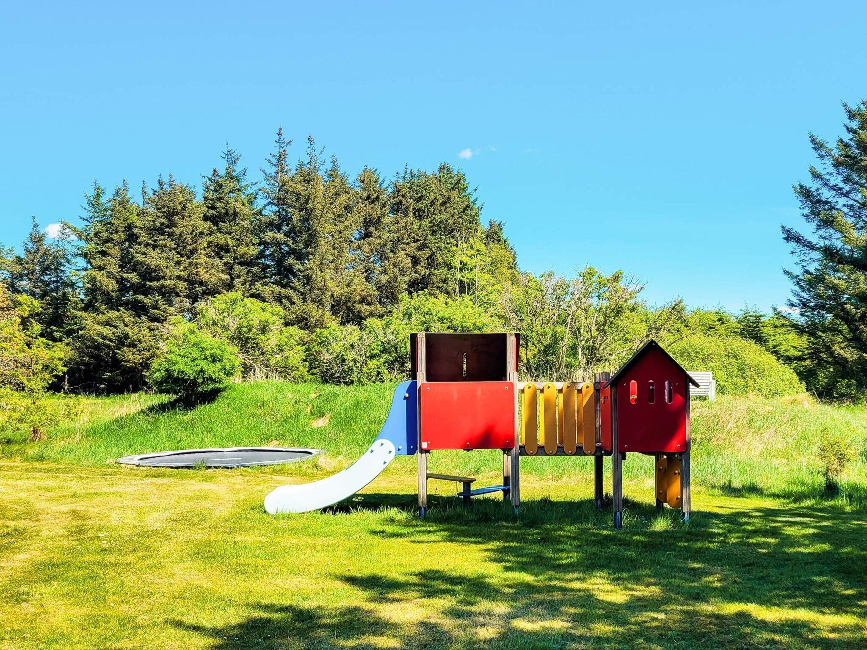 A playground with a slide, swing, and climbing structure.