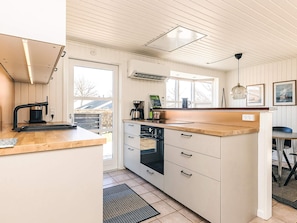 A kitchen with a wooden countertop, a coffee maker, a kettle, and a window. - 5 Star Holiday Home in Hals (Hals)