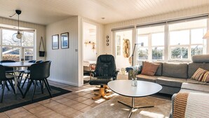 Ett rymligt vardagsrum med ett matbord, stolar, en soffa och ett soffbord.