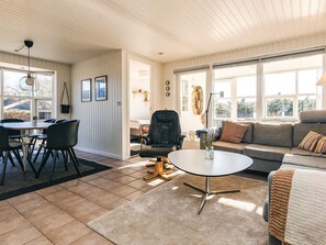 A spacious living area with a dining table, chairs, a sofa, and a coffee table. - 5 Star Holiday Home in Hals (Hals)