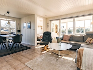 A spacious living area with a dining table, chairs, a sofa, and a coffee table. - 5 Star Holiday Home in Hals (Hals)