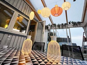 A dining area with a checkered table, two hanging paper lanterns, and a view through a window. - 8 Person Holiday Home in Tvaaker (Tvaaker)