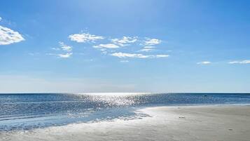 Una playa con cielo despejado y mar tranquilo.