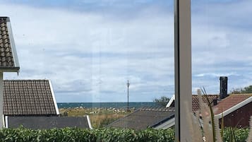 Zona residencial com casas, céu claro e uma linha de energia elétrica ao longe.