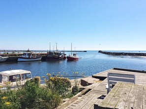 A marina with several boats docked, a wooden pier, and a clear blue sky. - 8 Person Holiday Home in Tvaaker (Tvaaker)