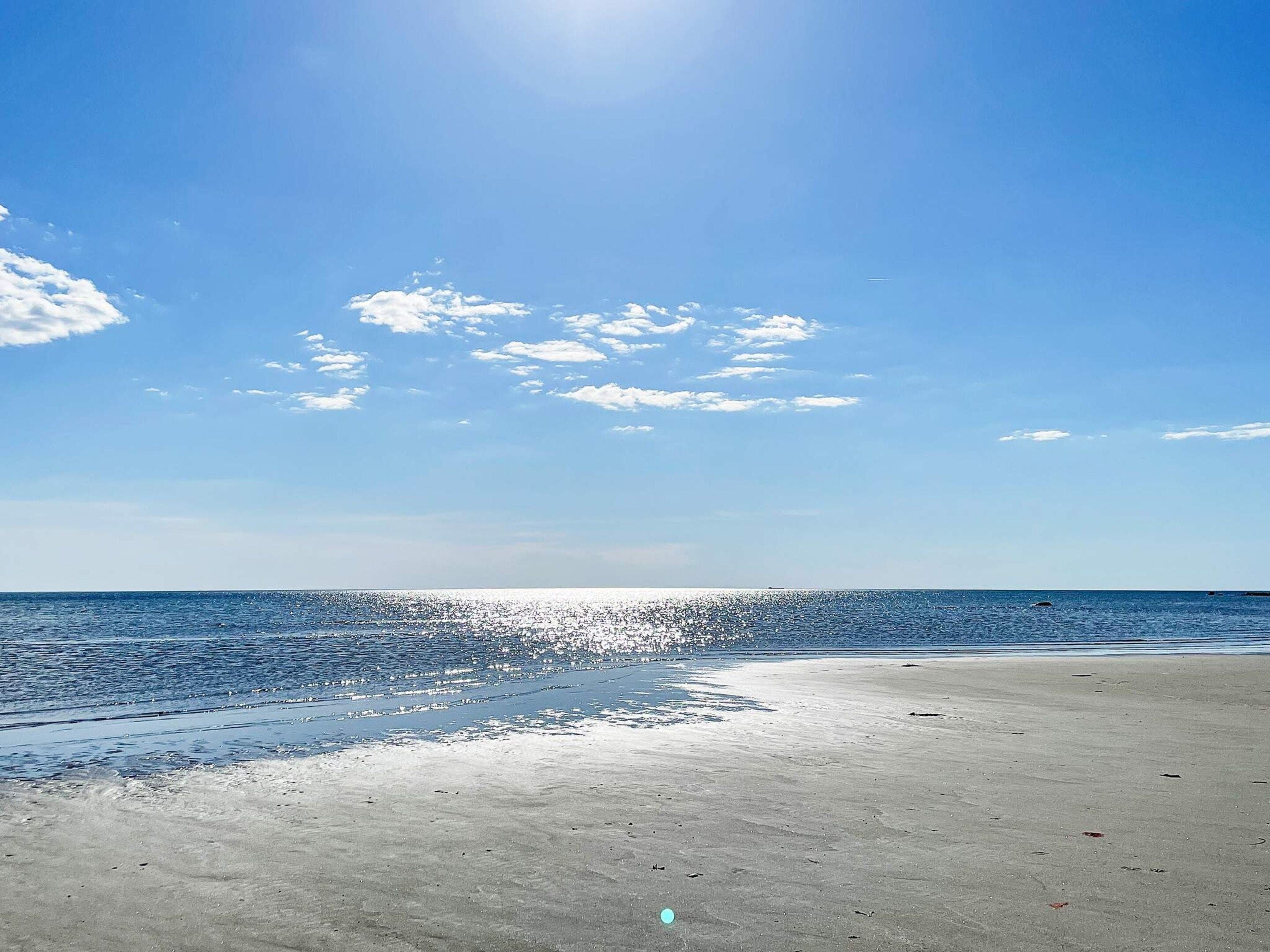 A beach with a clear sky and calm sea.