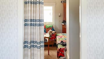 Un dormitorio con una cama, un escritorio y una silla.