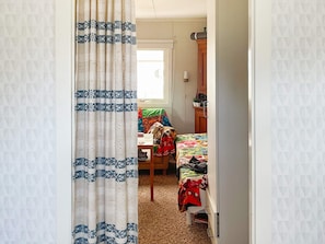 A bedroom with a bed, a desk, and a chair. - 8 Person Holiday Home in Tvaaker (Tvaaker)