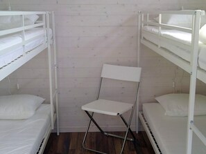 A bunk bed room with a foldable chair in the center. - 8 Person Holiday Home in Tvaaker (Tvaaker)