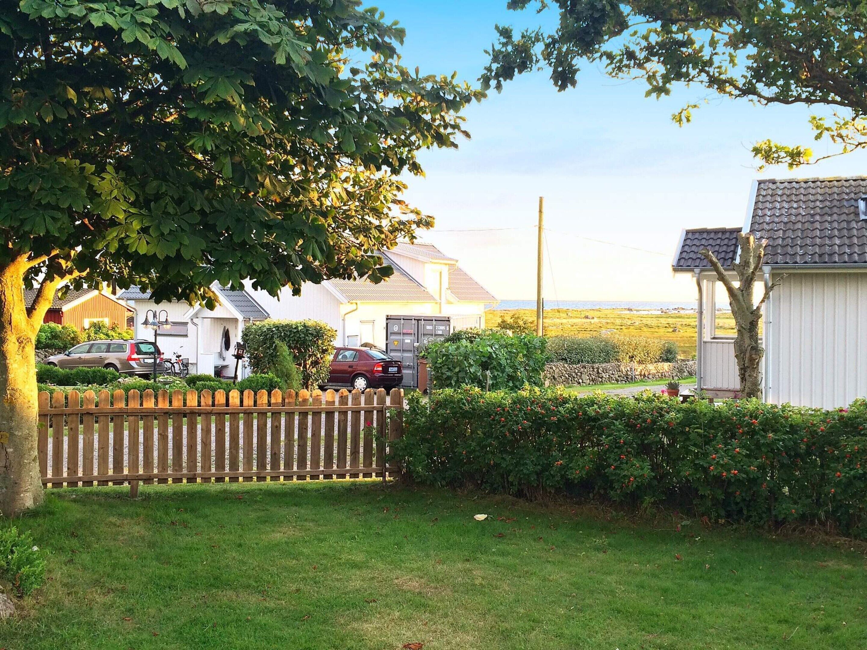 A residential area with houses, a wooden fence, and a grassy lawn.