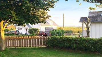 A residential area with houses, a wooden fence, and a grassy lawn.