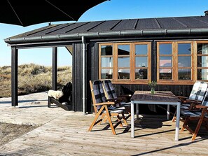 A wooden structure with large windows, outdoor seating, and a view of the surrounding landscape. - 4 Star Holiday Home in Hvide Sande (Hvide Sande)