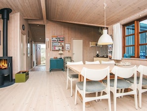 A wooden interior with a dining area, bookshelves, and a fireplace. - 4 Star Holiday Home in Hvide Sande (Hvide Sande)
