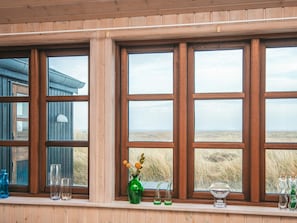 A room with large windows, wooden paneled walls, and a view of the landscape. - 4 Star Holiday Home in Hvide Sande (Hvide Sande)