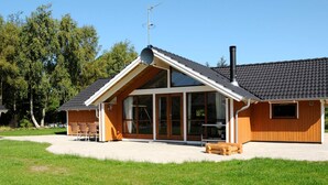 A modern building with a sloped roof, large windows, and a chimney. - 5 Star Holiday Home in Ulfborg (Ulfborg)