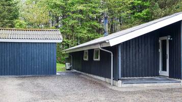 Un bâtiment doté d’un toit en métal, d’une porte et d’une fenêtre.