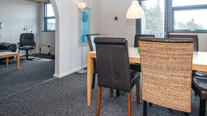 A conference room with a large table, black leather chairs, and a hanging light fixture. - 6 Person Holiday Home in Hvide Sande (Hvide Sande)