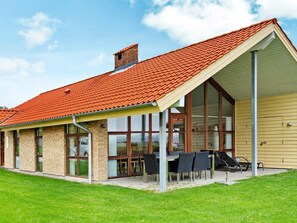 A modern house with a red-tiled roof, large windows, and a covered patio area. - 4 Star Holiday Home in Egernsund (Broager)