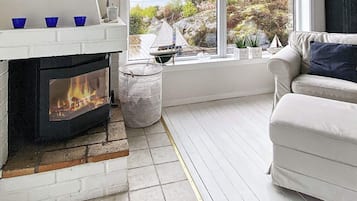 A living room with a fireplace, a sofa, and a view of the outdoors.