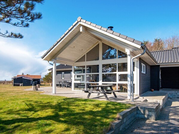 A house with a covered patio area, a visible garage, and a lawn. - 5 Star Holiday Home in Logstor (Logstor)