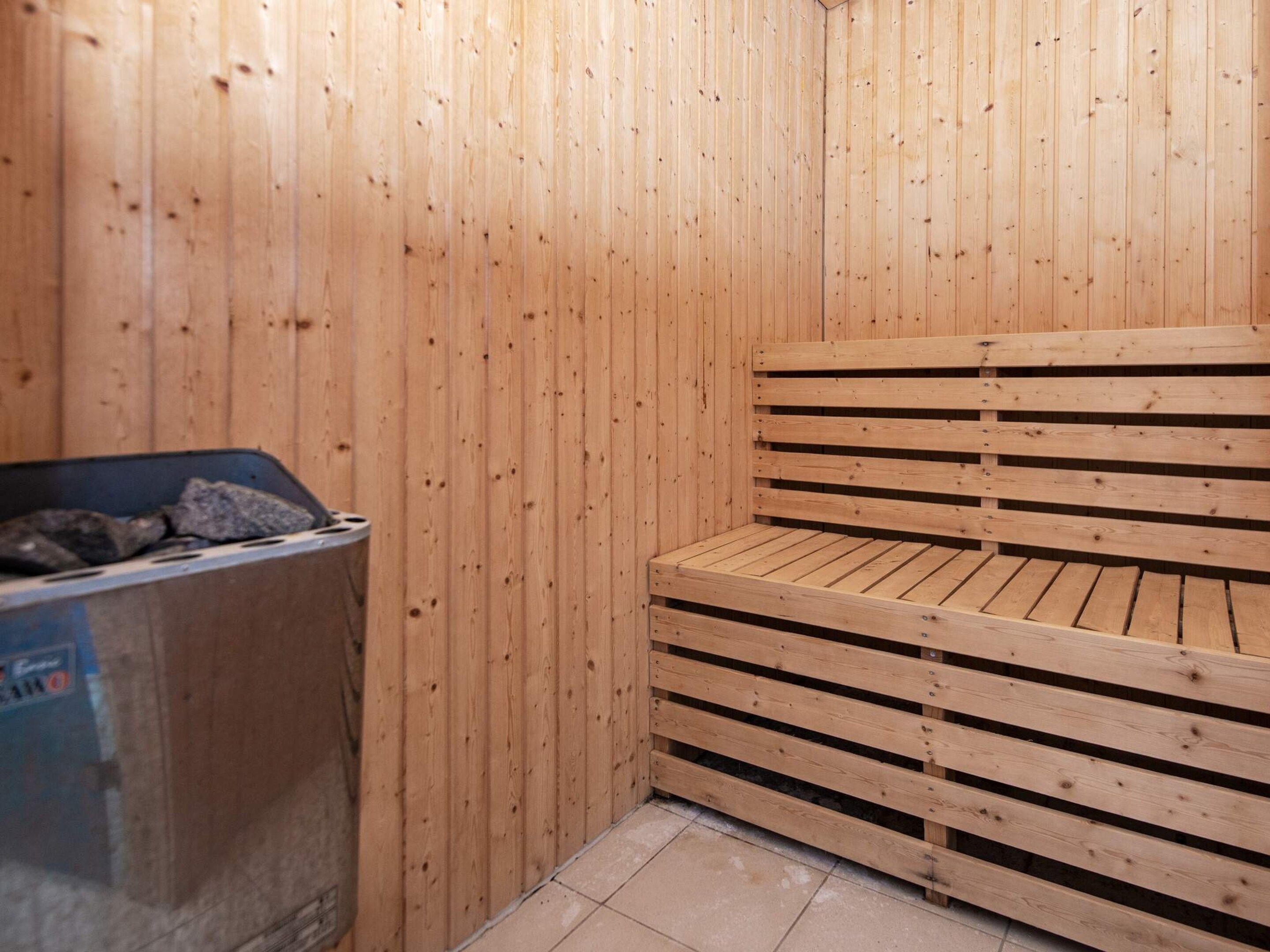 A sauna room with wooden walls and benches.