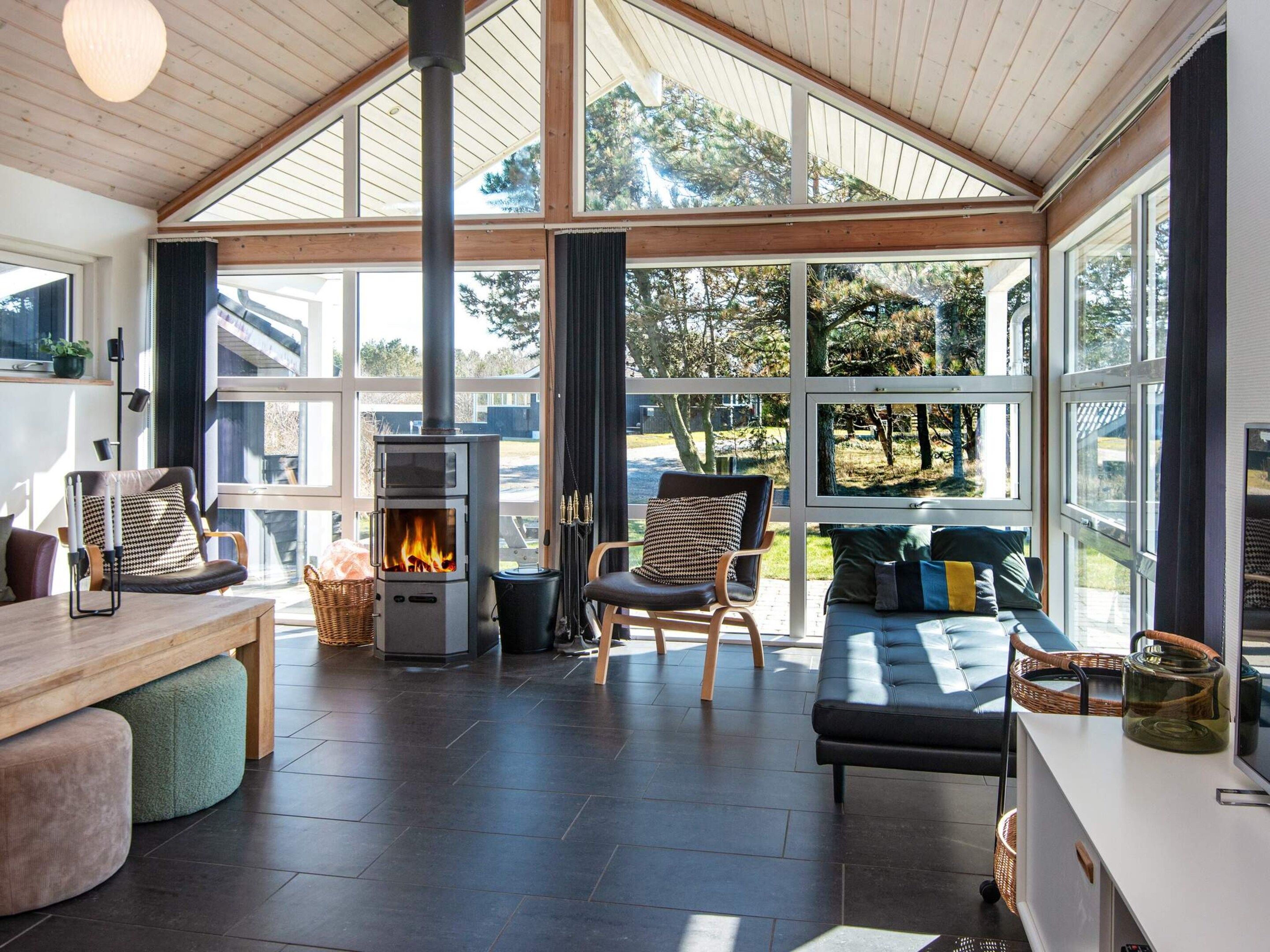 A spacious room with a large window, a fireplace, and a comfortable seating area.