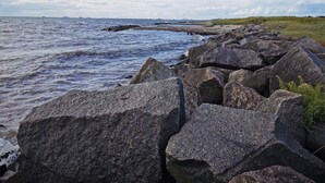 Une côte rocheuse où les vagues s'écrasent contre les rochers.