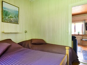 A room with two beds, a painting on the wall, and a window with a view. - 7 Person Holiday Home in Sunnemo (Sunnemo)
