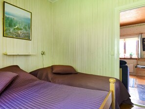 A room with two beds, a painting on the wall, and a window with a view. - 7 Person Holiday Home in Sunnemo (Sunnemo)