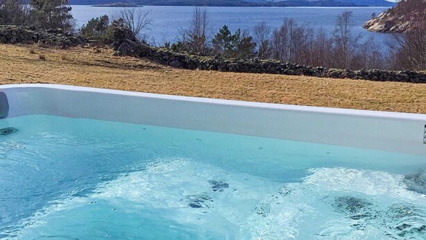 Una piscina con vistas a un lago y montañas.