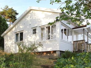 A white house with a porch and a small staircase leading to the entrance. - 4 Person Holiday Home in Uddevalla (Uddevalla)