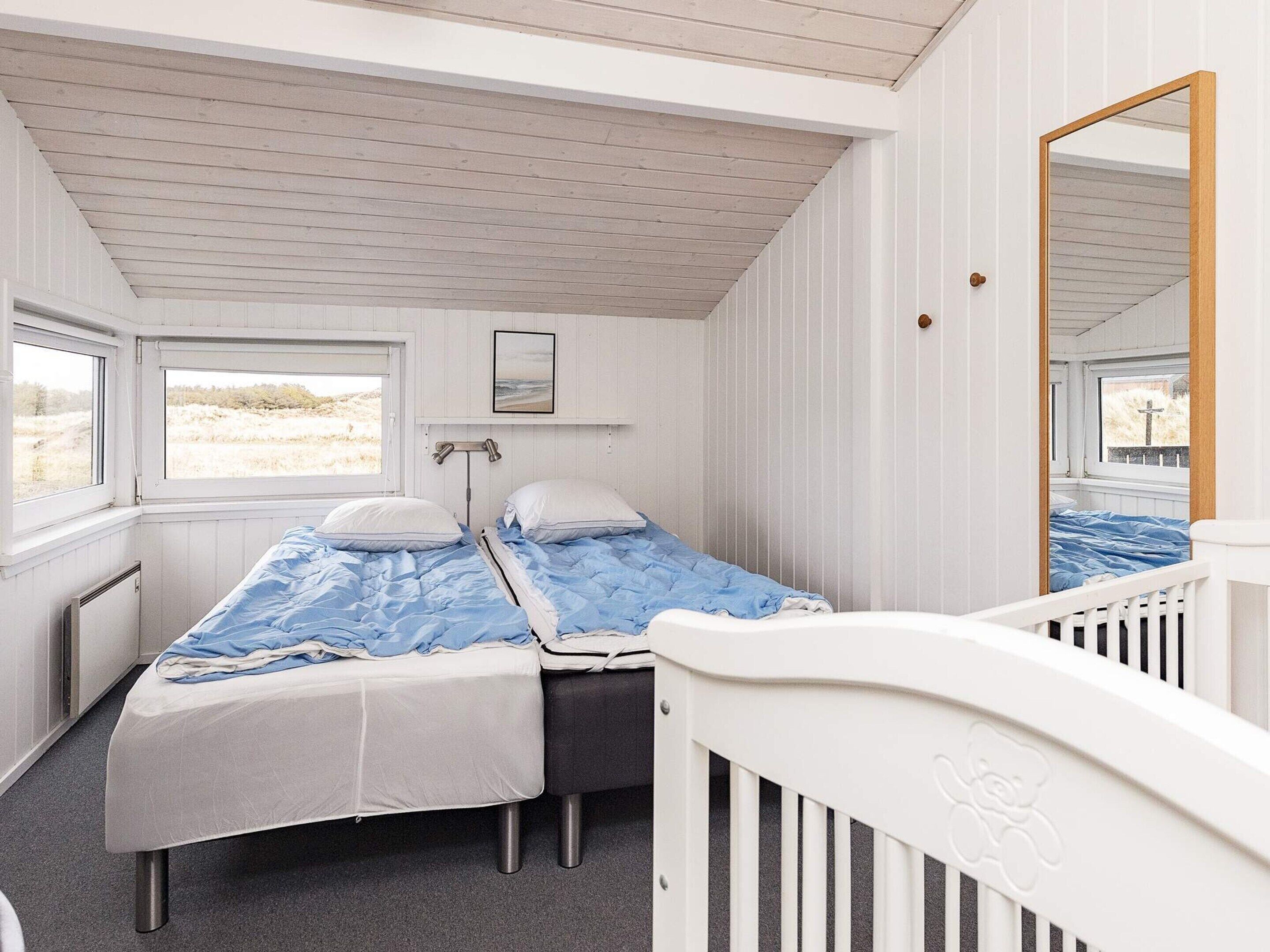 Une cabine équipée de deux lits, d’une fenêtre, d  ’un miroir et d’un radiateur.