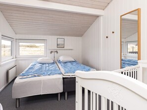 Une cabine équipée de deux lits, d’une fenêtre, d’un miroir et d’un radiateur.