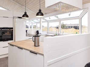 Een moderne keuken met een groot raam, een koffiezetapparaat en een Siemens oven.