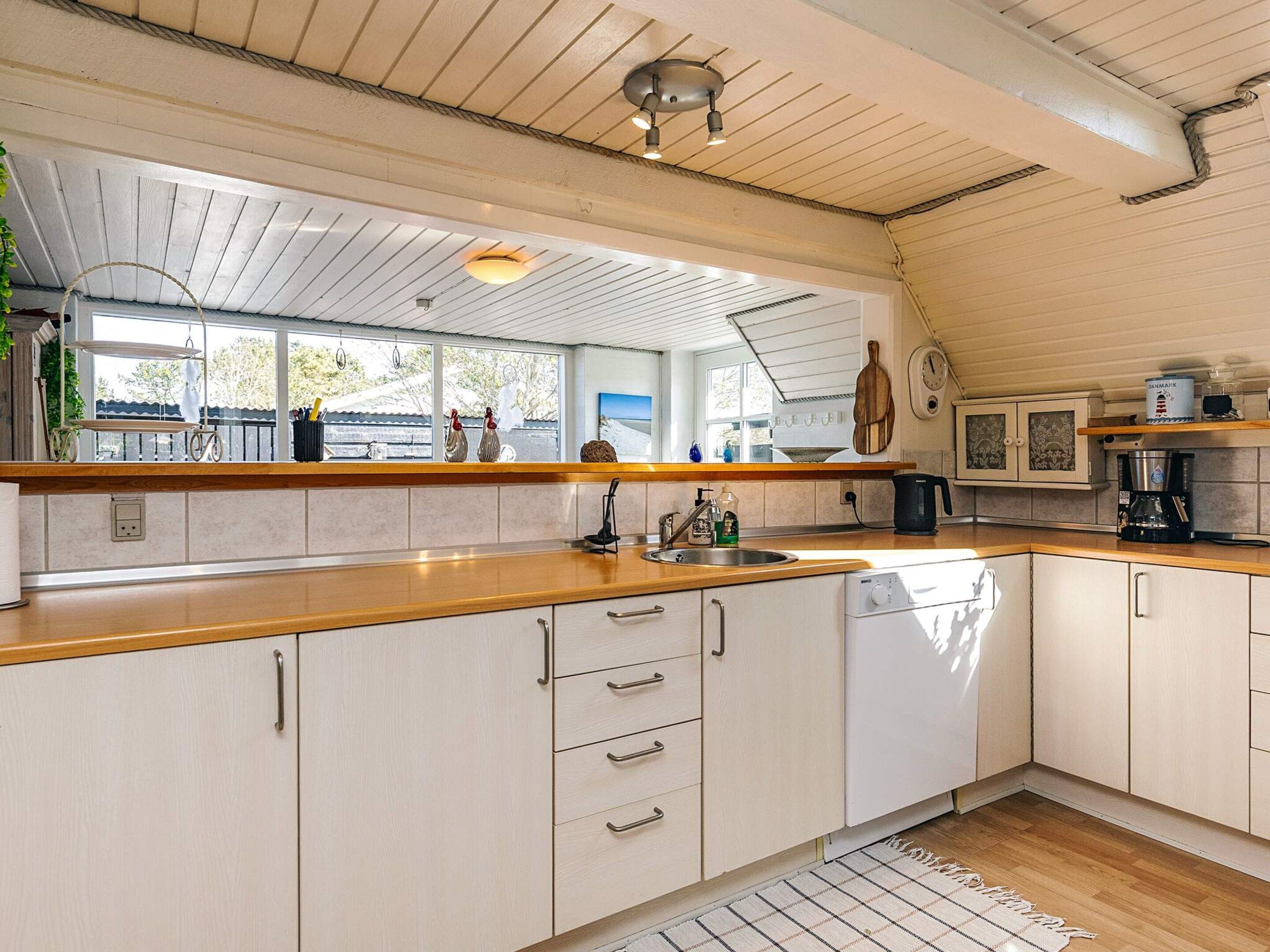 A kitchen with wooden cabinets, a sink, and a coffee maker.