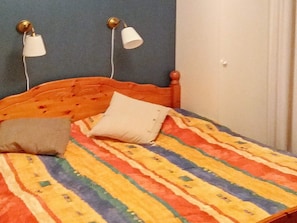 A bed with a colorful striped bedspread, two bedside lamps, and a pillow. - Holiday Home in Ljungskile (Ljungskile)